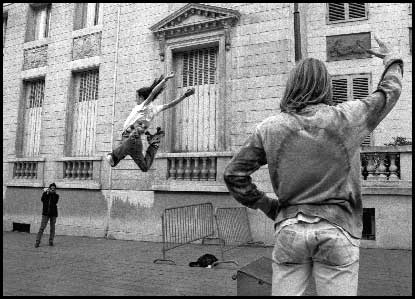 Skater jumping makeshift barrier while being photographed